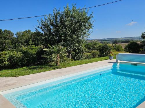 - une piscine bleue avec un banc à côté dans l'établissement Chez Magali, à Salvagnac