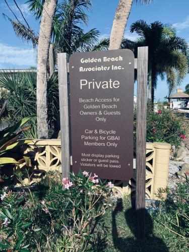 a sign for a pineapple resort with palm trees at 2 BR Home With Private Beach Access To Golden Beach - Luna Sea in Venice