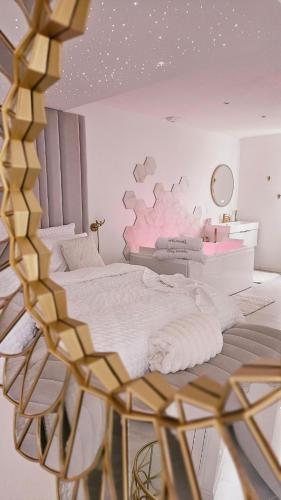 une chambre avec un lit avec un mur rose dans l'établissement Douceur Dorée, à Yville-sur-Seine