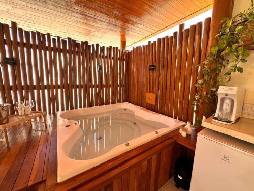a large bath tub in a room with wooden walls at Urban dream, chalé temático in Goiânia