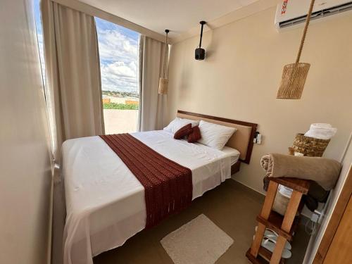 a bedroom with a bed and a window and a chair at Urban dream, chalé temático in Goiânia