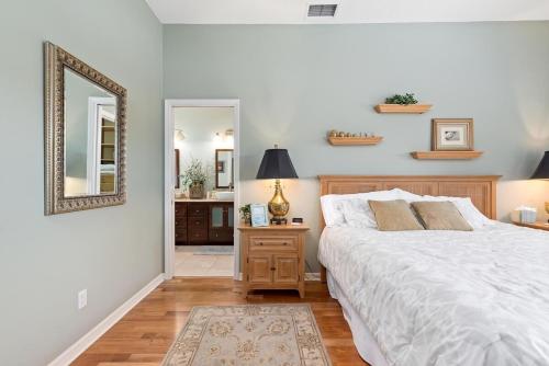 a bedroom with a large bed and a mirror at Tranquil 2BR lakefront home in Palmer Ranch in Sarasota
