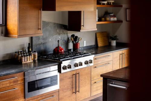 a kitchen with wooden cabinets and a stove top oven at Architects Dream Home - Secluded Mountain Retreat in Golden