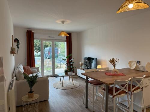 une salle à manger et un salon avec une table et des chaises dans l'établissement L'Hibiscus, à Saint-Jean-de-Monts