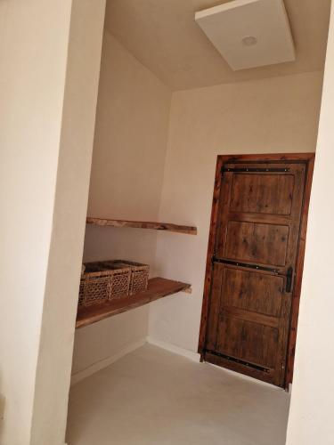 a room with a wooden door and a shelf at Bassya Villa in Zarzis