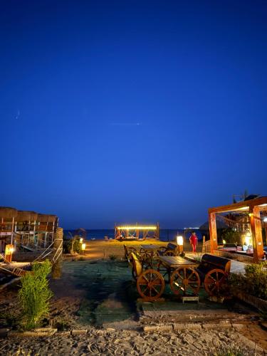 a group of tables and carts on the beach at night at Green Beach Camp & Hotel in Nuweiba