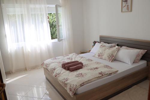 a bedroom with a bed with a brown suitcase on it at Pampas Family Apartment in Dobrota