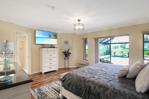 une chambre avec un grand lit et une télévision dans l'établissement Private 3BR Pool Home - Punta Gorda - Pet Friendly - Paraclete Paradise, à Punta Gorda