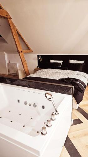 - une baignoire dans une chambre avec un lit dans l'établissement Black Romance, à Yville-sur-Seine