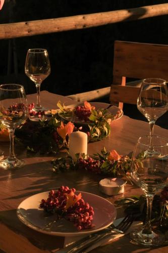 a table with a candle and wine glasses on it at House In The Mountains-Heshkili in Keshkili