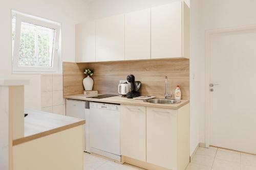 a kitchen with white cabinets and a sink at Andrea Lux in Kotor