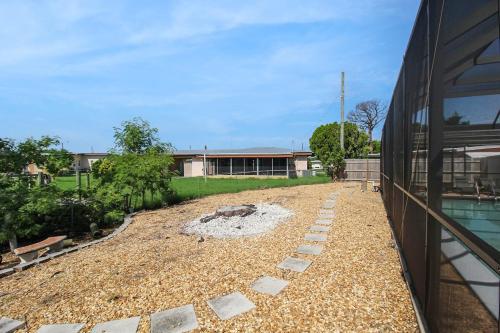 a backyard with a fire pit next to a building at Canal-Front Escape with Private Pool & Game Room in Port Charlotte in Port Charlotte