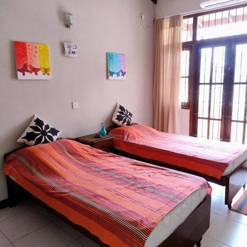 a bedroom with two beds and a window at A tropical paradise; stunning house, pool, garden in Wattala