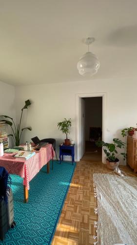 - un salon avec deux tables et un tapis vert dans l'établissement Appartement ensoleillé et central à Marseille, à Marseille