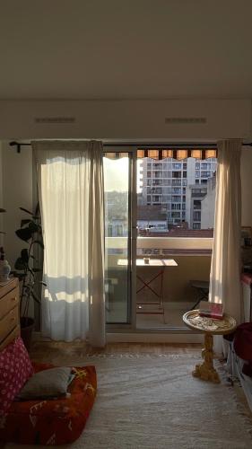 - un salon doté d'une fenêtre offrant une vue sur la ville dans l'établissement Appartement ensoleillé et central à Marseille, à Marseille