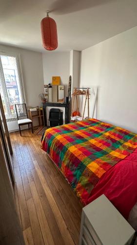 - une chambre avec une couverture colorée sur un lit dans l'établissement 27marmar27 - culture et détente, à Suresnes