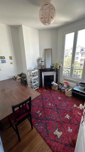 un salon avec une table et un tapis rouge dans l'établissement 27marmar27 - culture et détente, à Suresnes