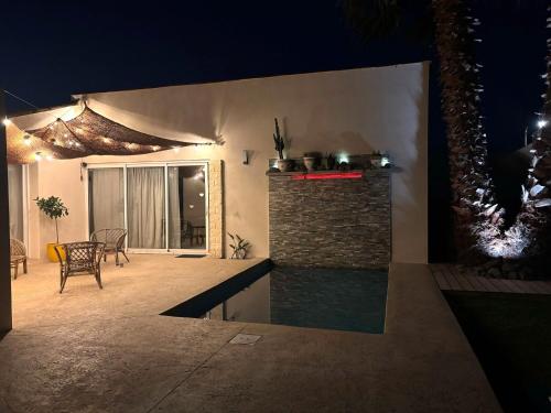 - un salon avec une cheminée et une terrasse la nuit dans l'établissement Villa Bali, à Tourbes