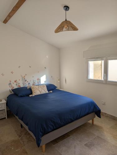 une chambre avec un lit avec une couette bleue dans l'établissement Villa Bali, à Tourbes