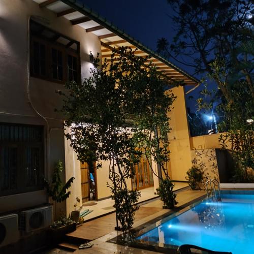a house with a swimming pool at night at A tropical paradise; stunning house, pool, garden in Wattala