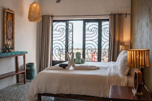 a bedroom with a bed and a large window at Casa Salita in Sayulita