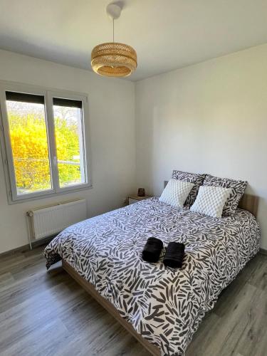 - une chambre dotée d'un lit avec deux chaussures noires dans l'établissement Gîte des Passants, à Tourville-sur-Arques