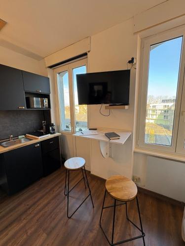 - une cuisine avec un bureau et deux tabourets dans la chambre dans l'établissement Modern Studio in Mulhouse Perfect for a Stay, à Mulhouse