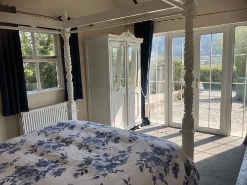 a bedroom with a bed with a blue and white comforter at Blue Lodge - by the sea, sauna, BBQ, private garden and parking in Aberystwyth