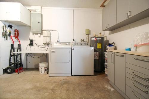 una cucina con mobili bianchi, lavatrice e asciugatrice di Delightful 2 BR Home in West Bradenton - Sans Souci a Bradenton