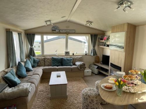 a living room with a couch and a table at 3 Bed-Sleeps 8-Pet Friendly-Parking-Sea View in Exmouth