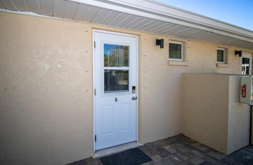 a white door on the side of a building at Charming Manasota Key duplex with beach access- IB14 in Englewood