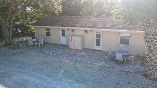 a house with a table and chairs in front of it at Charming Manasota Key duplex with beach access- IB14 in Englewood