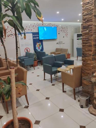 a waiting room with chairs and a flat screen tv at منتجع شاطئ الدولفين للإيواء السياحي in Yanbu