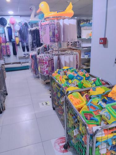 a store aisle with baskets of toys and other items at منتجع شاطئ الدولفين للإيواء السياحي in Yanbu
