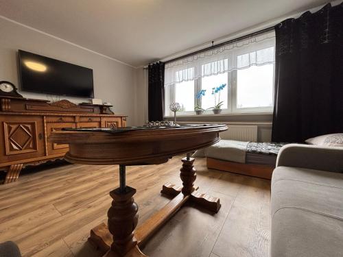 a living room with a table in the middle of a room at Apartamenty nad Zatoką in Jastarnia