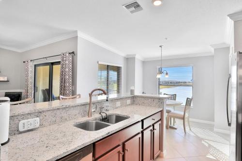 Breathtaking 3 BR condo with lake views in Lakewood National Golf Club - Shades Of Summer في برادنتون: مطبخ مع حوض وإطلالة على المحيط