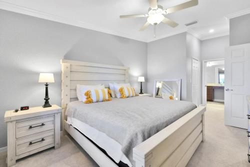 Breathtaking 3 BR condo with lake views in Lakewood National Golf Club - Shades Of Summer في برادنتون: غرفة نوم بيضاء مع سرير كبير ومروحة سقف