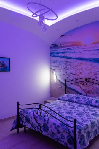 a bedroom with a bed with a painting of the ocean at Ammiria in Cetara