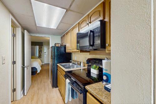 a small kitchen with a sink and a refrigerator at Oceanfront Paradise in Myrtle Beach