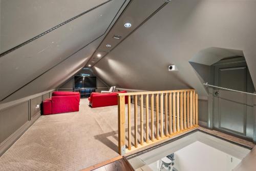 an attic room with red chairs and a staircase at Private completely fenced in property Near beach in Hampton Bays