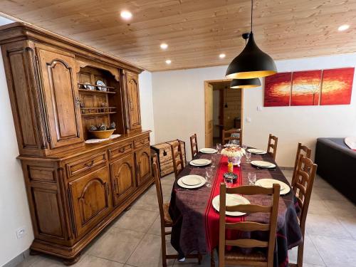 une salle à manger avec une table et une grande armoire en bois dans l'établissement Gîte Mija, à Saint-Jean-Saint-Nicolas