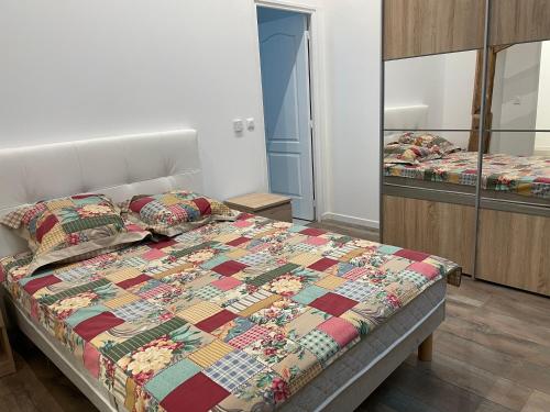 une chambre avec un lit avec une couette dessus dans l'établissement APPARTEMENT MODERNE DANS FERME DU 13éme SIECLE, à Fontaine-Chaâlis