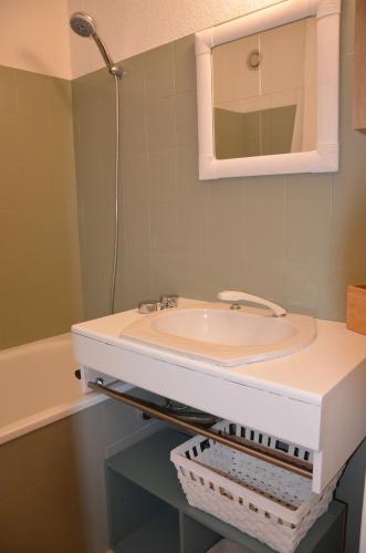 une salle de bain avec un lavabo et un miroir dans l'établissement Studio chaleureux à Barcelonnette avec balcon et vue montagne, à Barcelonnette