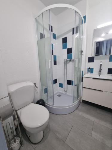 une salle de bain avec des toilettes blanches et une douche dans l'établissement Front de mer, Wifi, joli appartement 4 couchages, secteur Lydia Grande plage, au Barcarès