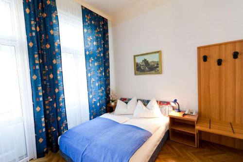 a bedroom with a bed with a blue blanket at Hotel-Pension Bleckmann in Vienna