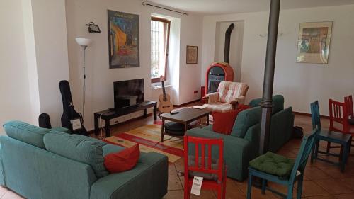 a living room with couches and chairs and a fireplace at Montino Coliving in Oggebbio