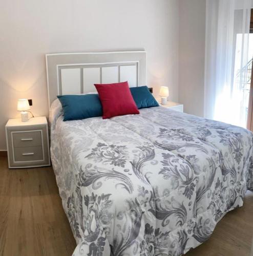 a bedroom with a large bed with a red pillow at El Abuelo Manuel in Monachil