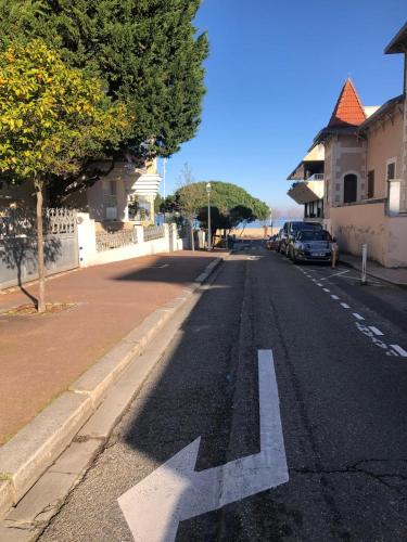 an empty street with an arrow painted on the road at Elégant T2 près de la plage et en hyper centre in Arcachon