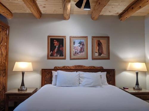 a bedroom with a bed and three pictures on the wall at Sagebrush Inn & Suites in Taos