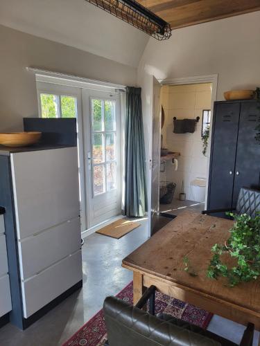 a kitchen with a wooden table in a room at Lodge bij Broer in Smilde